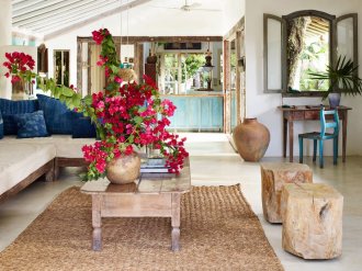 Anderson Cooper enlisted fashion designer turned hotelier Wilbert Das to build him a vacation home in Trancoso, Brazil. Dubbed Casa Anderson, the estate comprises four buildings. In the main structure’s living/dining room, a vintage Bahian cocktail table mingles with pequi-wood stools and pieces from Das’s Uxua Casa home collection, including the indigo-dyed throw pillows, woven-reed rug, and sectional sofa.